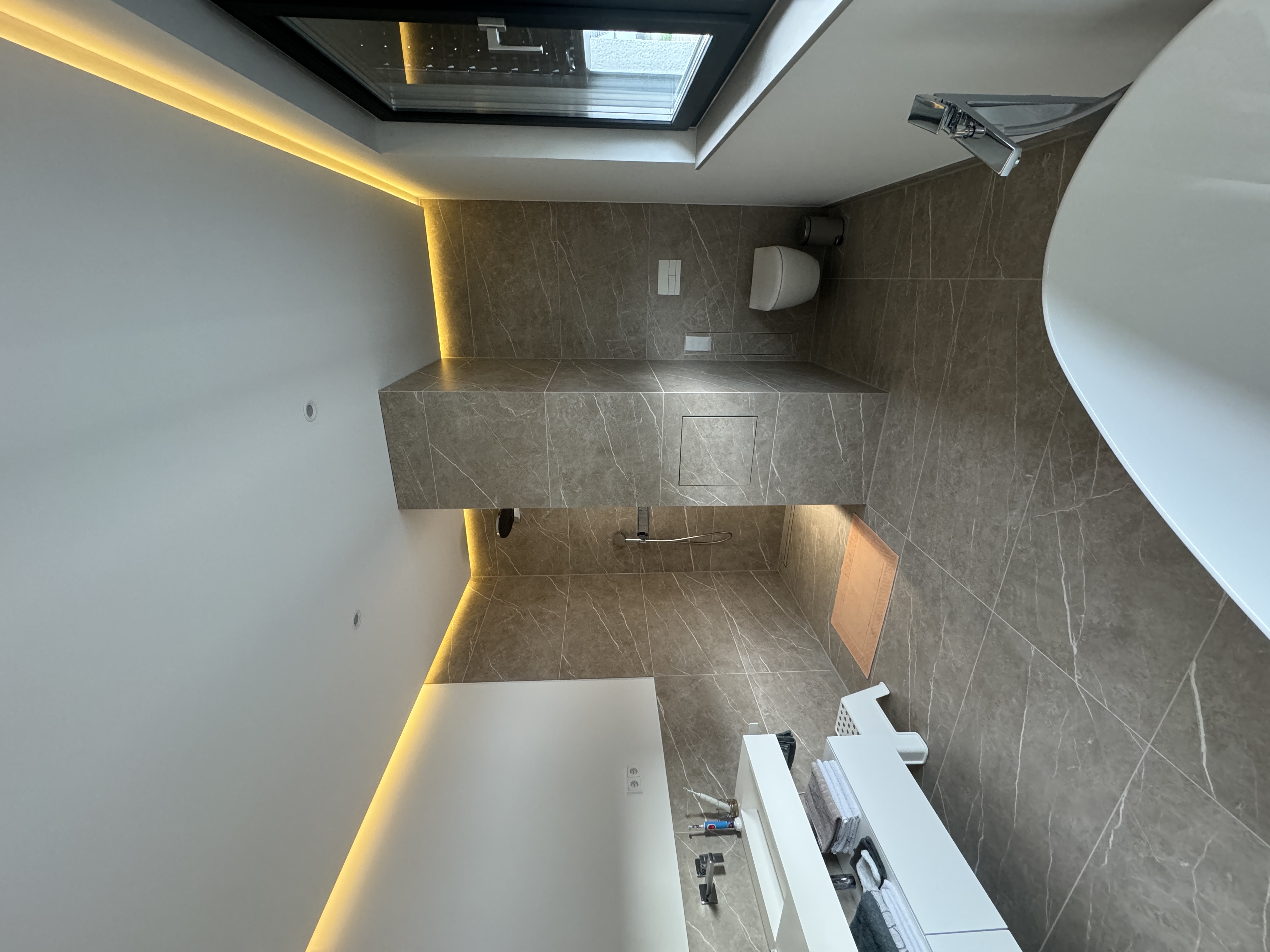 Großzügiges Badezimmer mit Dusche, freistehender Wanne und gefliester Trennwand