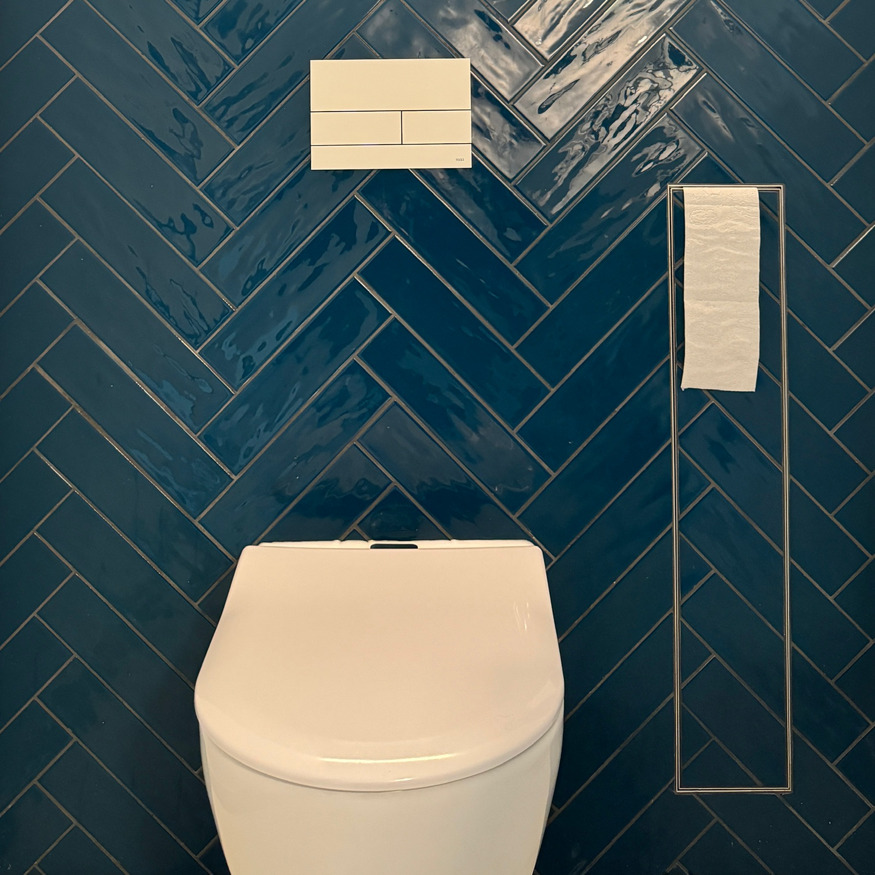 In die geflieste WC-Wand integrierter Papierhalter neben einem wandhängenden WC in Kerpen