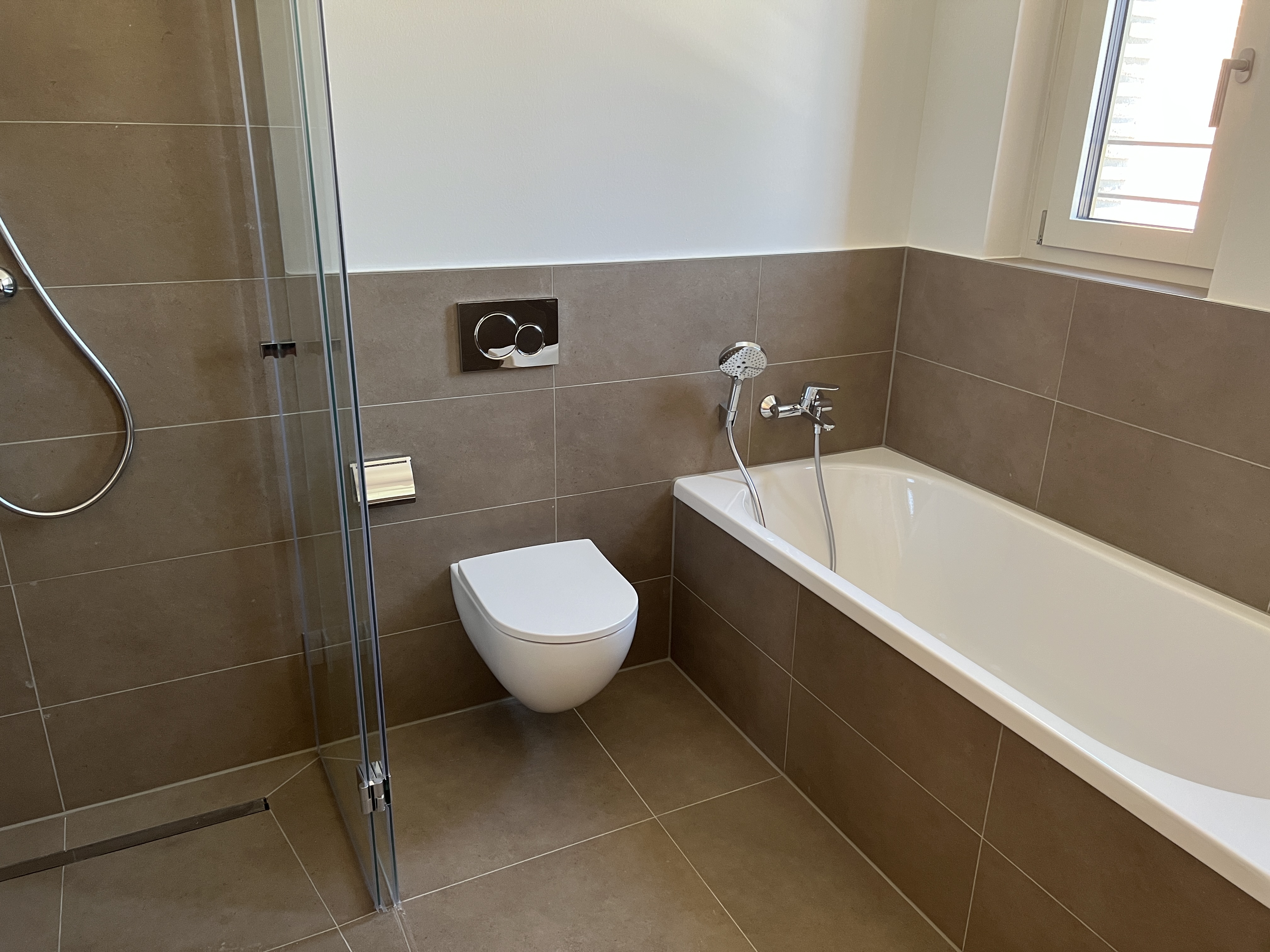 Geflieste Badewannenverkleidung mit braunen 30 × 60 cm Fliesen