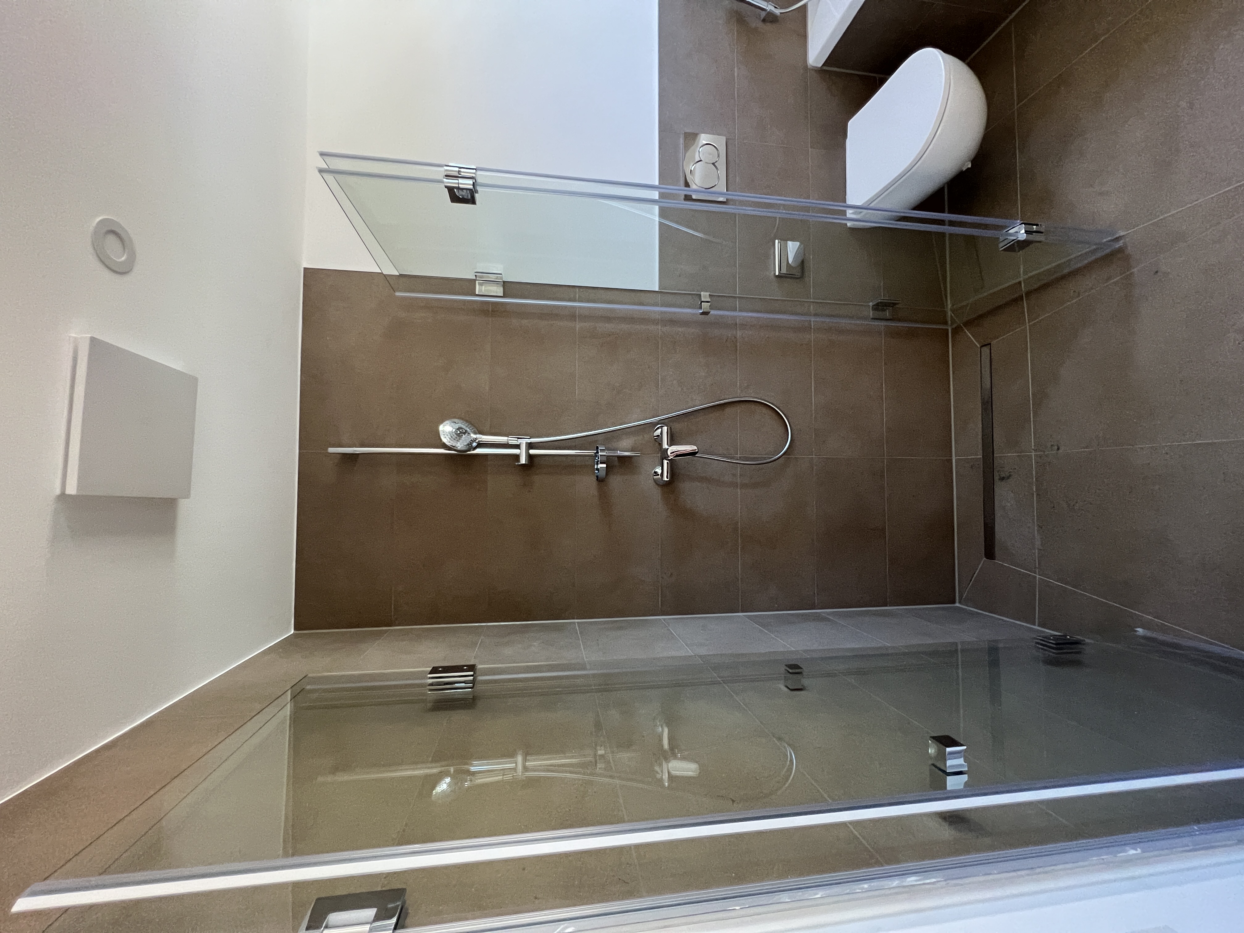 Bodenebene Dusche und WC mit braunen 30 × 60 cm Fliesen im Wohn- und Geschäftshaus in Düren